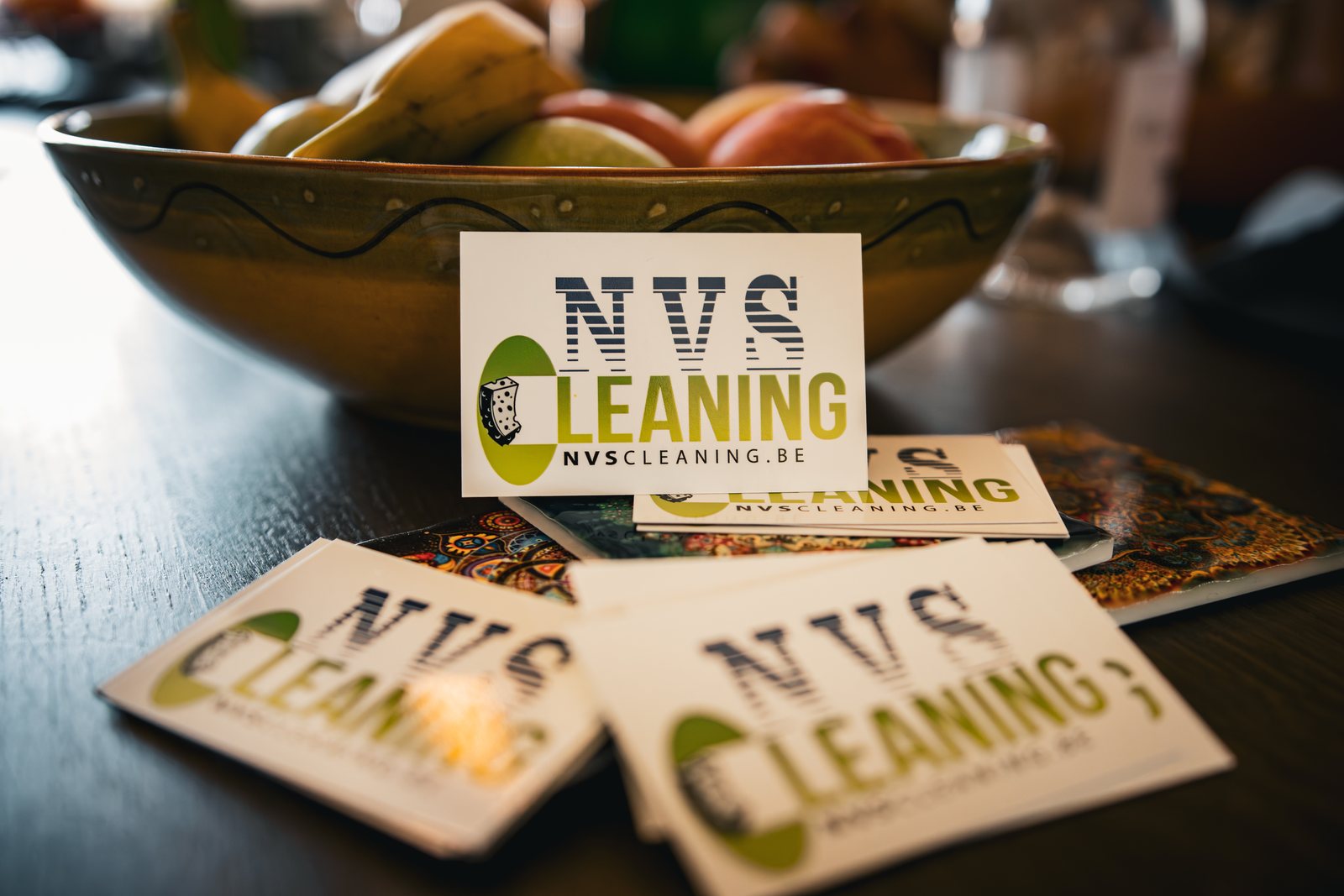 Visitekaartjes van NVS Cleaning naast een fruitschaal